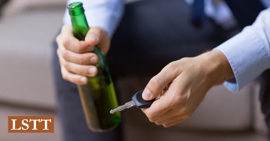 man drinking and holding car keys